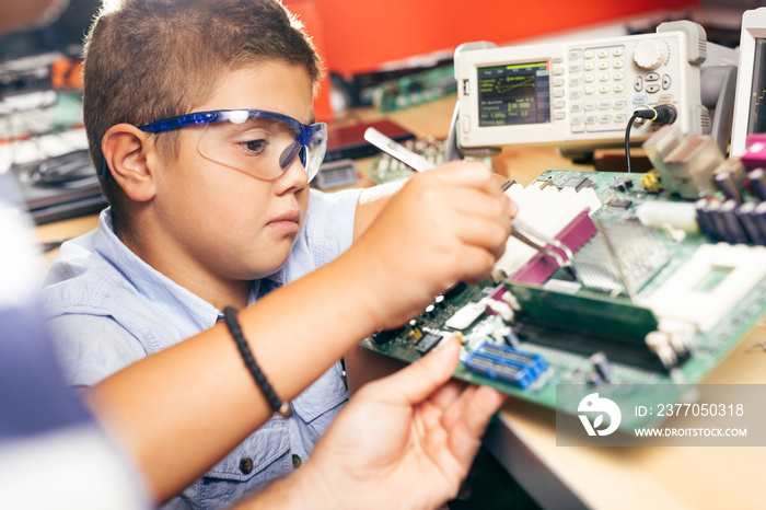 Young boy working on an electronics project