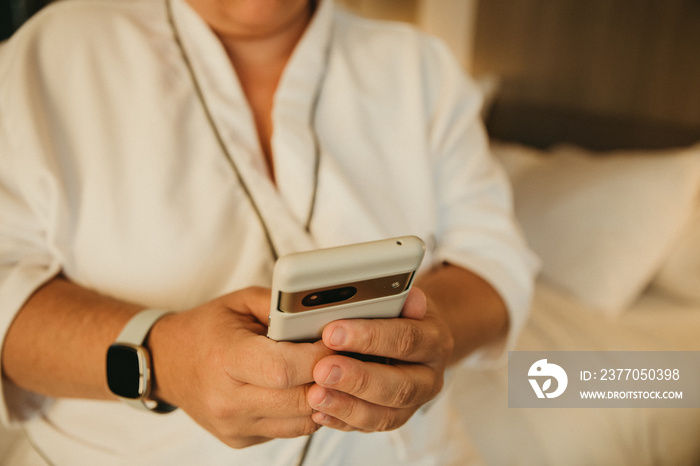 close up of plus size hands holding phone wearing health tracker