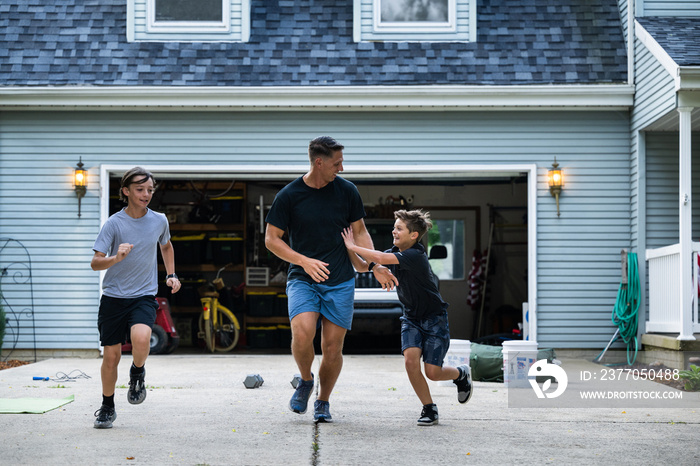 Air Force service member trains with his sons in a morning workout in preperation for a PT fitness test.