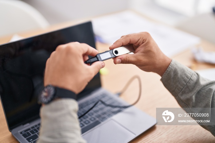 Young hispanic man using crypto cold wallet at office