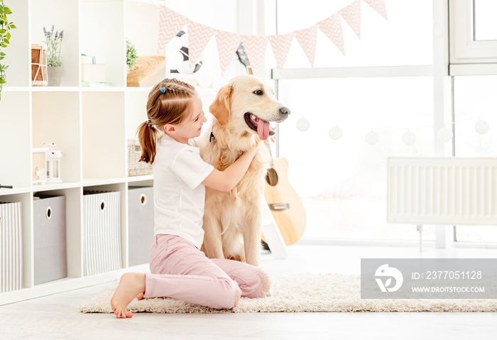 Happy little girl cuddling beautiful dog