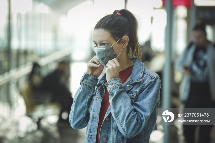 Woman wearing protective mask in airport, Coronavirus contagion fears concept