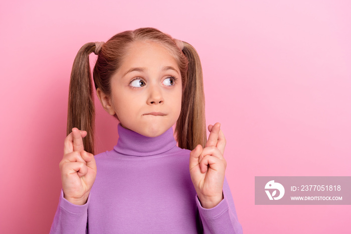 Photo of young lovely little female cross fingers in anticipation want birthday present isolated on pink color background