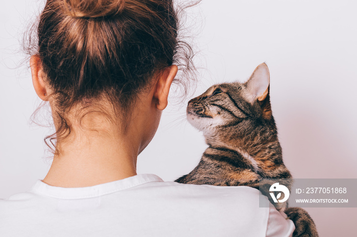 Tabby cat sitting on female shoulder