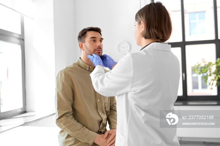 medicine, healthcare and people concept - female doctor checking lymph nodes of man patient at hospital