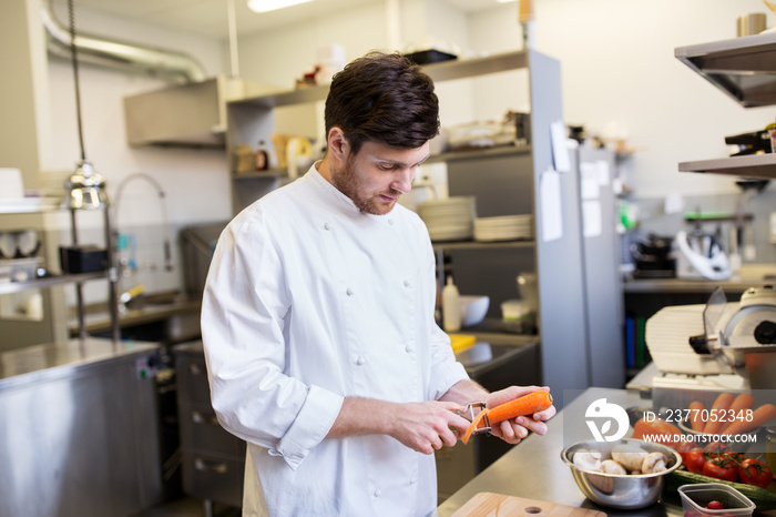 happy male chef cooking food at restaurant kitchen