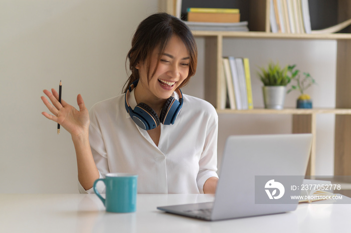 Female worker say hi to her  coworkers while video conference, work from home concept