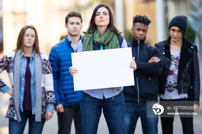 Diverse group of people protesting with blank sign