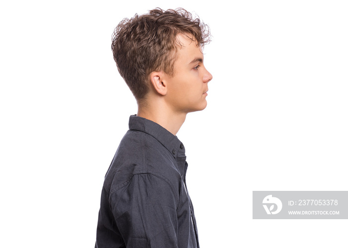 Side view of portrait of teen boy in black shirt, isolated on white background. Happy child - profile. Schoolboy looking away.