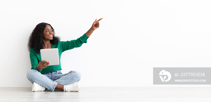 Happy black woman with pointing at empty space, panorama