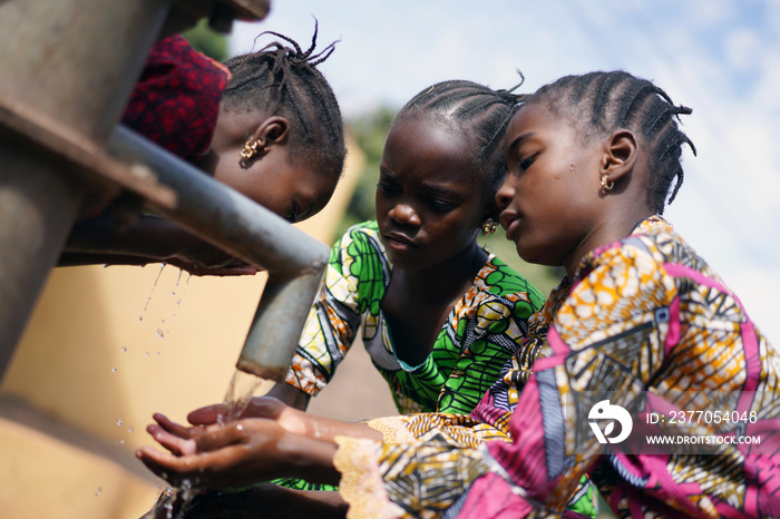 African Women with Hands under Water Faucet