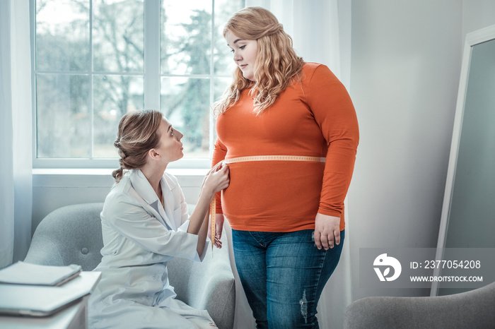 Delighted oversized woman listening to her dietician