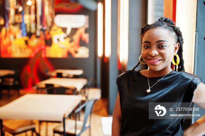 Close up portrait african woman in black blouse at cafe.