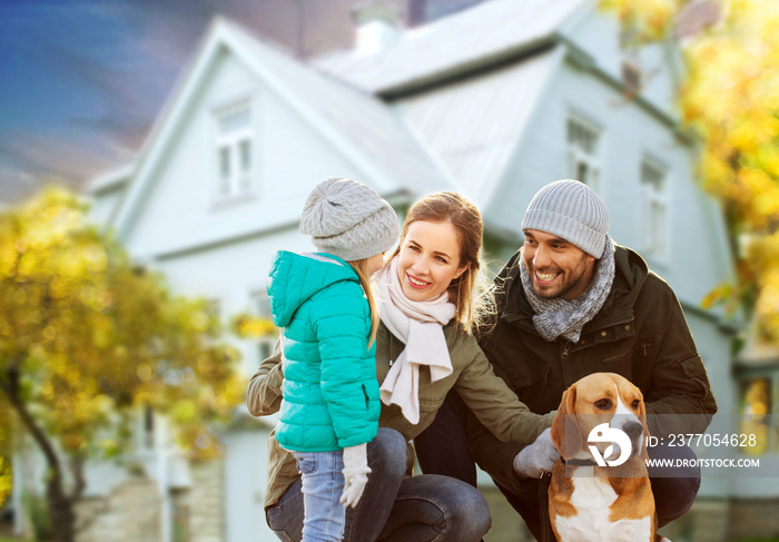 family, pets and people concept - happy mother, father and little daughter with beagle dog outdoors over house in autumn background