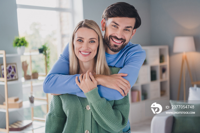 Portrait of two attractive cheerful careful people bonding enjoying spending time staying at home indoors