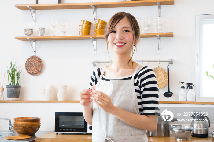 キッチンで料理を作る若い主婦