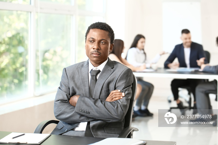 Lonely African-American businessman in office. Stop racism