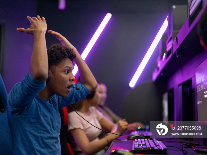 Frustrated young man playing video games with friends in gaming club