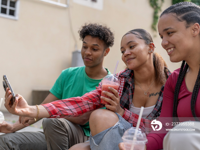 Friends taking selfie while drinking smoothie