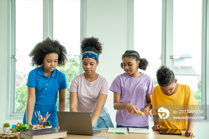 Happy school children using digital tablet in classroom at school,Black school student learning online education program app technology during lesson.