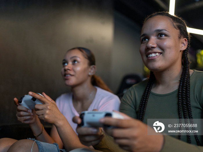 Female friends playing video games in gaming club