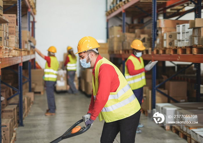 People working inside warehouse while wearing safety face masks for coronavirus outbreak