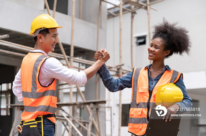 Mechanical Engineer team shaking hands while working on construction home building site