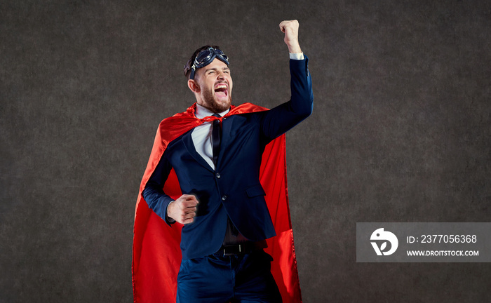 A businessman in a superhero costume is a winner. The concept of success victory.