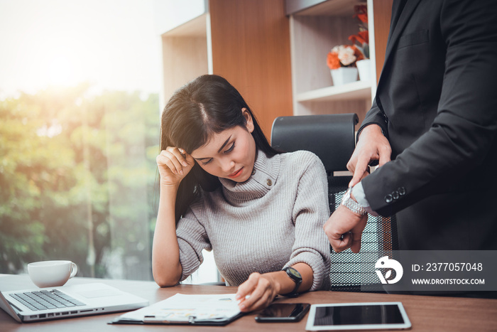 Boss showing watch to stressed business woman with working missed deadline