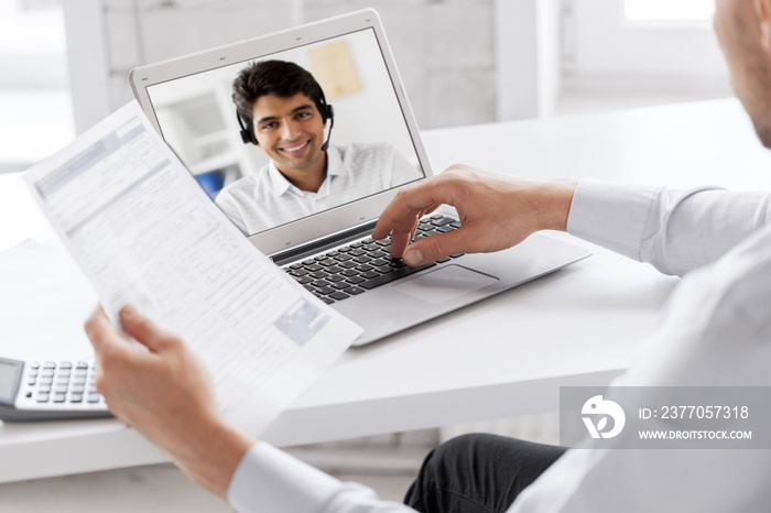 business, technology and communication concept - close up of businessman with laptop computer having video call with customer service operator, partner or secretary at office