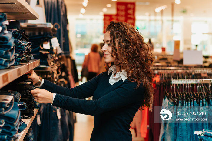 Shopper looking at clothing indoors in store.