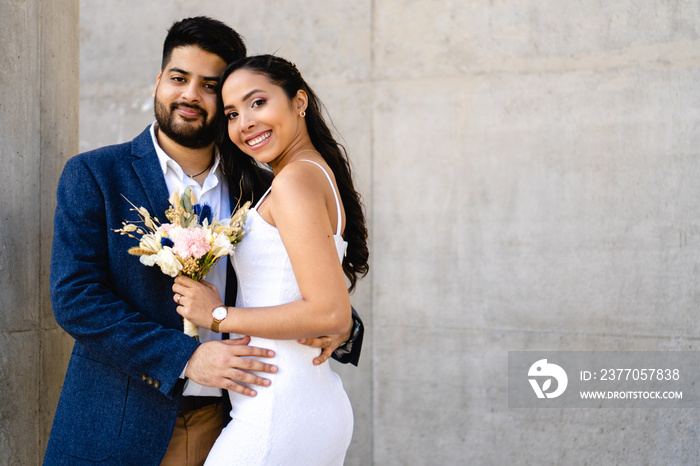 photo of the bride and groom with wedding bouquet, looking at the camera, copy space