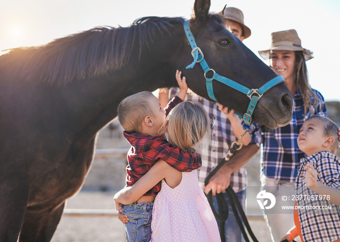 Happy family enjoy day outdoor with horse at ranch - Parents, children and animal love concept