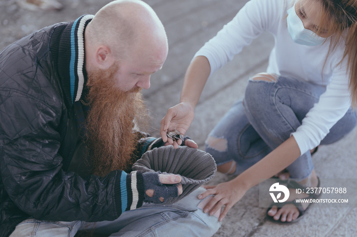 female giving money to poor or homeless people poverty beggar in the city sitting on the streets with a sign for help., homeless poor people and depression concepts.