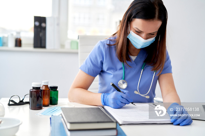 Female doctor filling out medical records