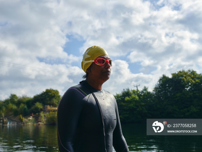 Woman in swimming cap and goggles standing in river