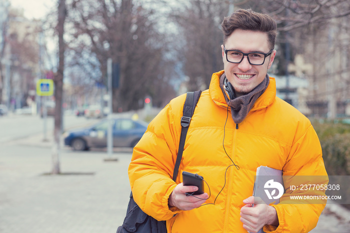 Stylish happy man in coat walking on street