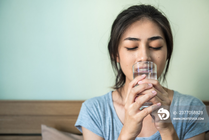 Young healthy woman drinking water after getting in the morning.