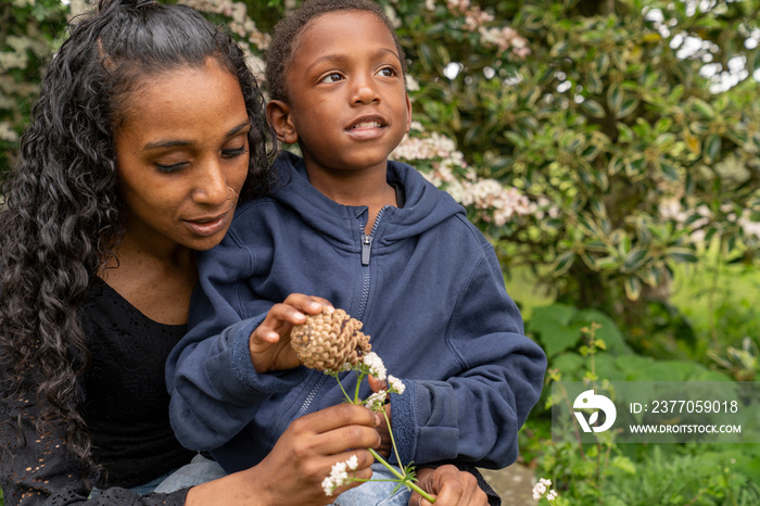 Mother and son holding flower and pine cone