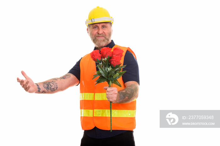 Happy mature bearded man construction worker smiling while givin