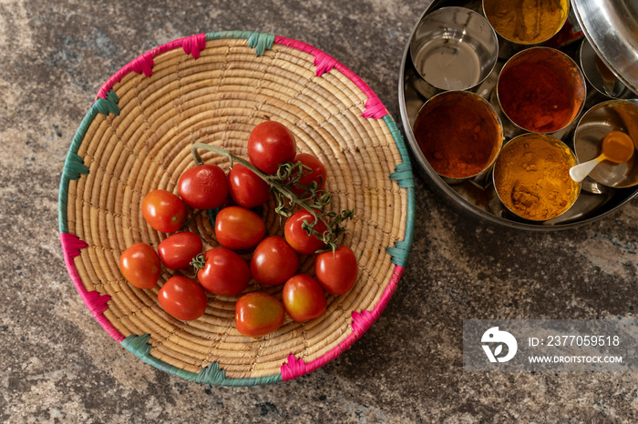 Cherry tomatoes and dried spices on kitchen counter