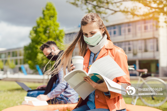 Woman student on college campus learning wearing face mask