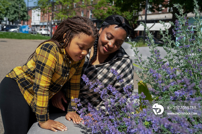 Mother and daughter (6-7) looking at flowers in park