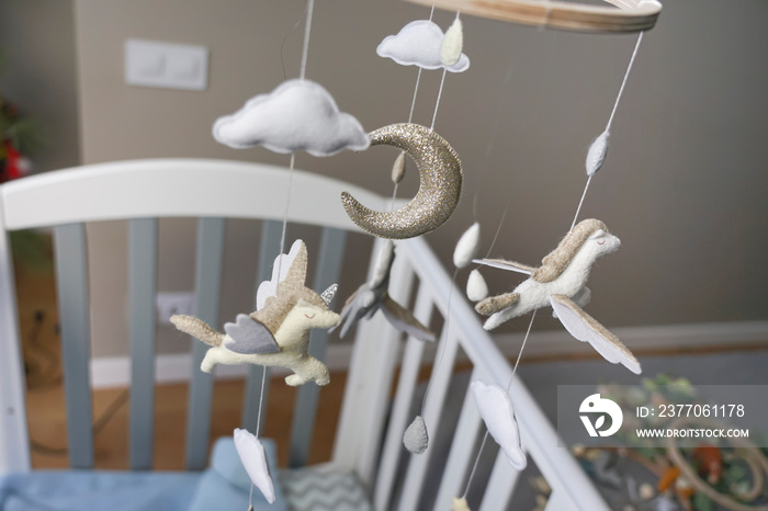 Diy craft baby crib mobile. Toys hang over the crib