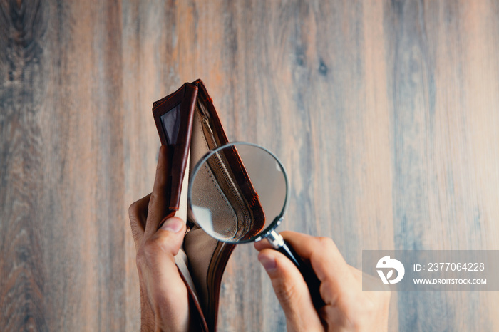 businessman holding a magnifying glass and wallet