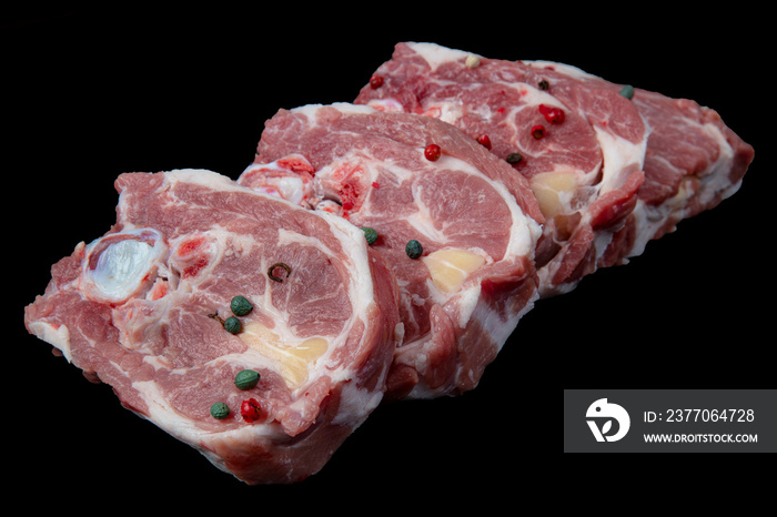 Lamb mutton meat (loin, back, shoulder, brisket and neck) on a wooden black background.