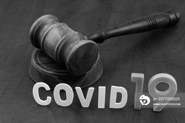 Wooden gavel with word covid19. Concept of quarantine and law against covid-19.