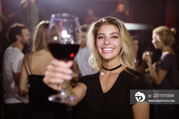 Portrait of smiling young woman holding wineglass