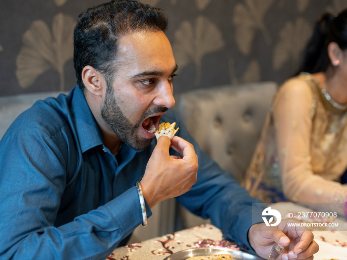 Man eating traditional Indian food at home