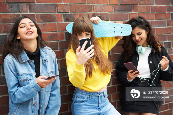 Three young women having fun with mobile phone